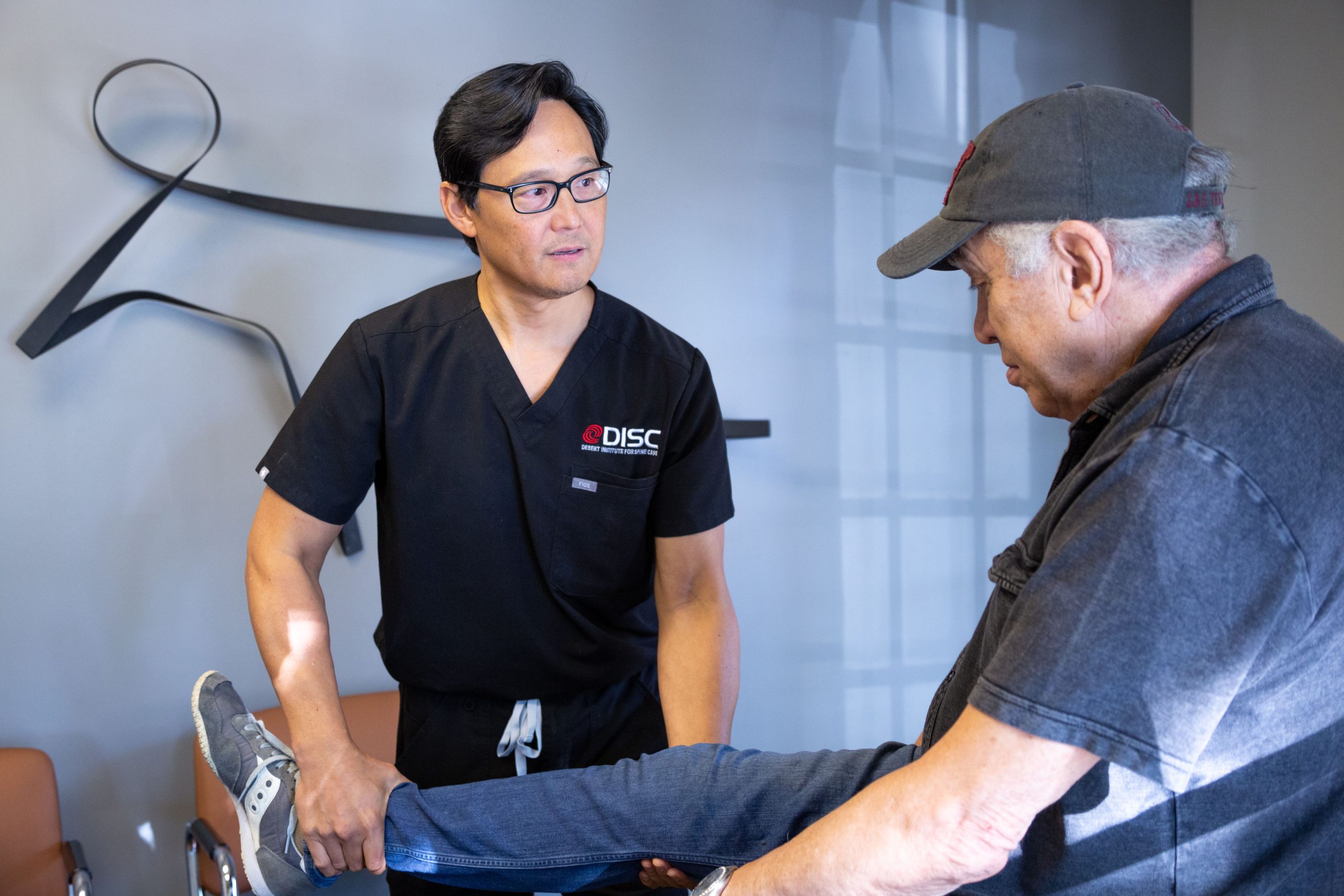 Dr. Chris Yeung Holding Leg of Elderly Patient