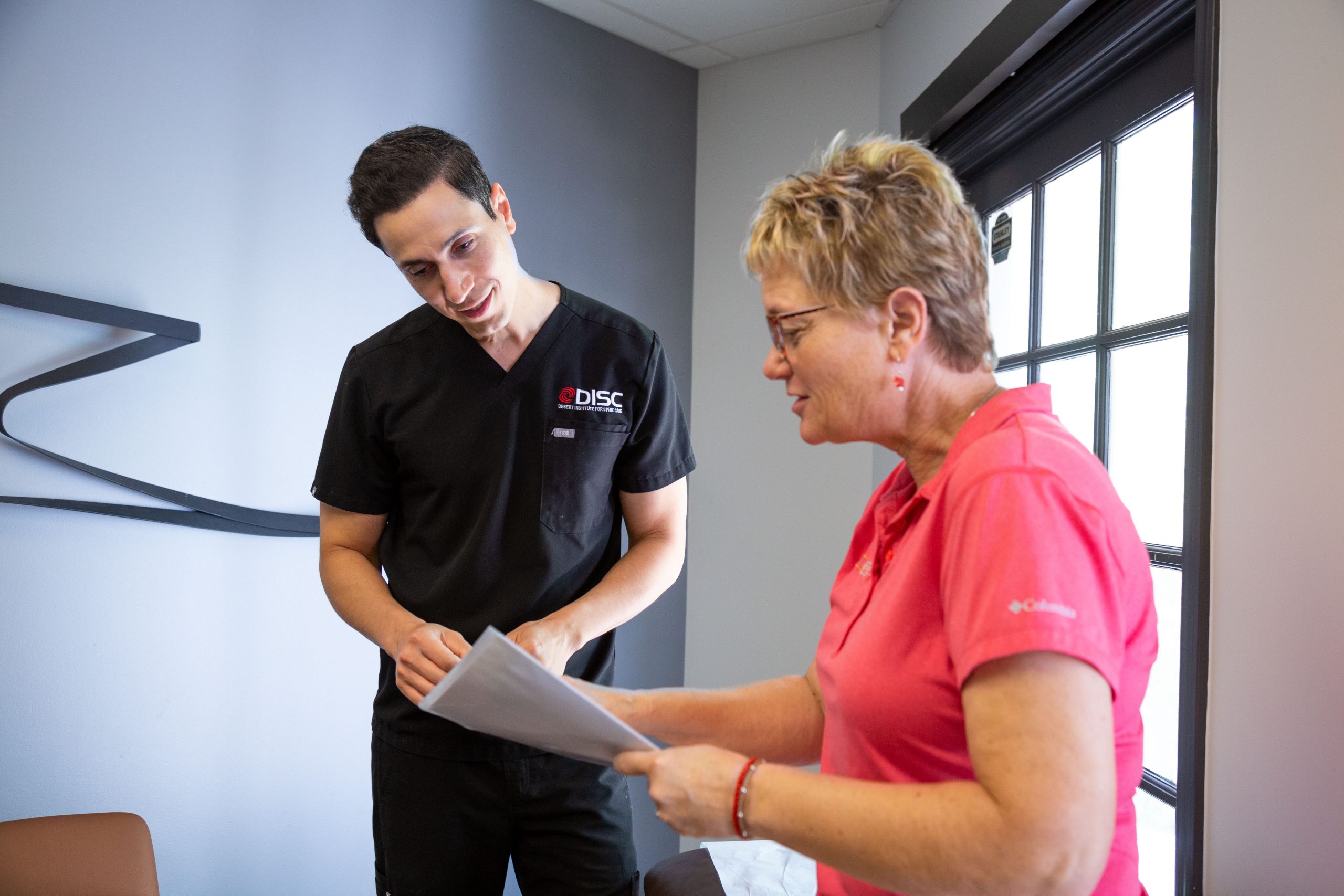 Dr. Salari Talks To A Woman In A Pink Shirt