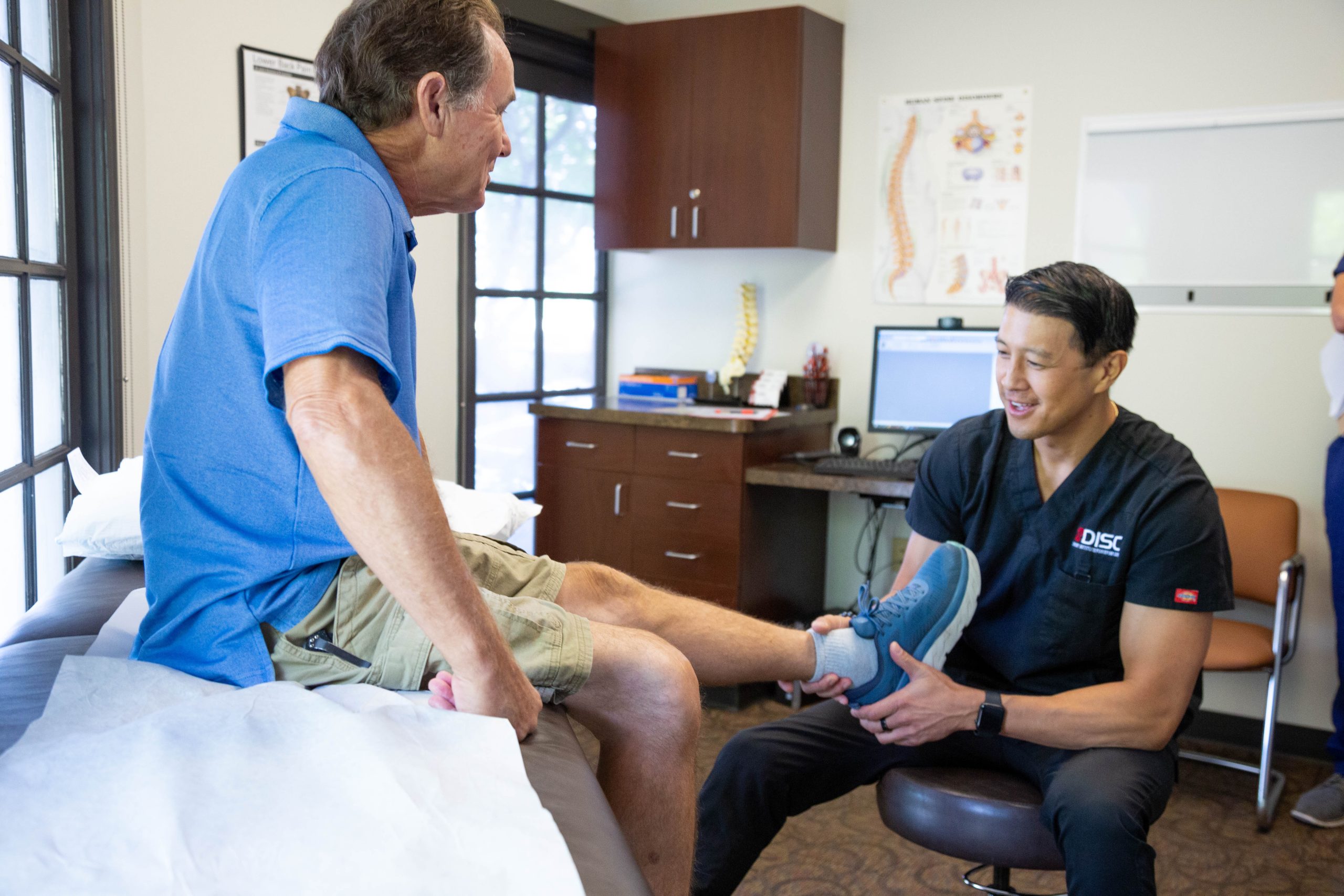 A Man In A Blue Shirt Is Being Examined By Dr. Mark Wang